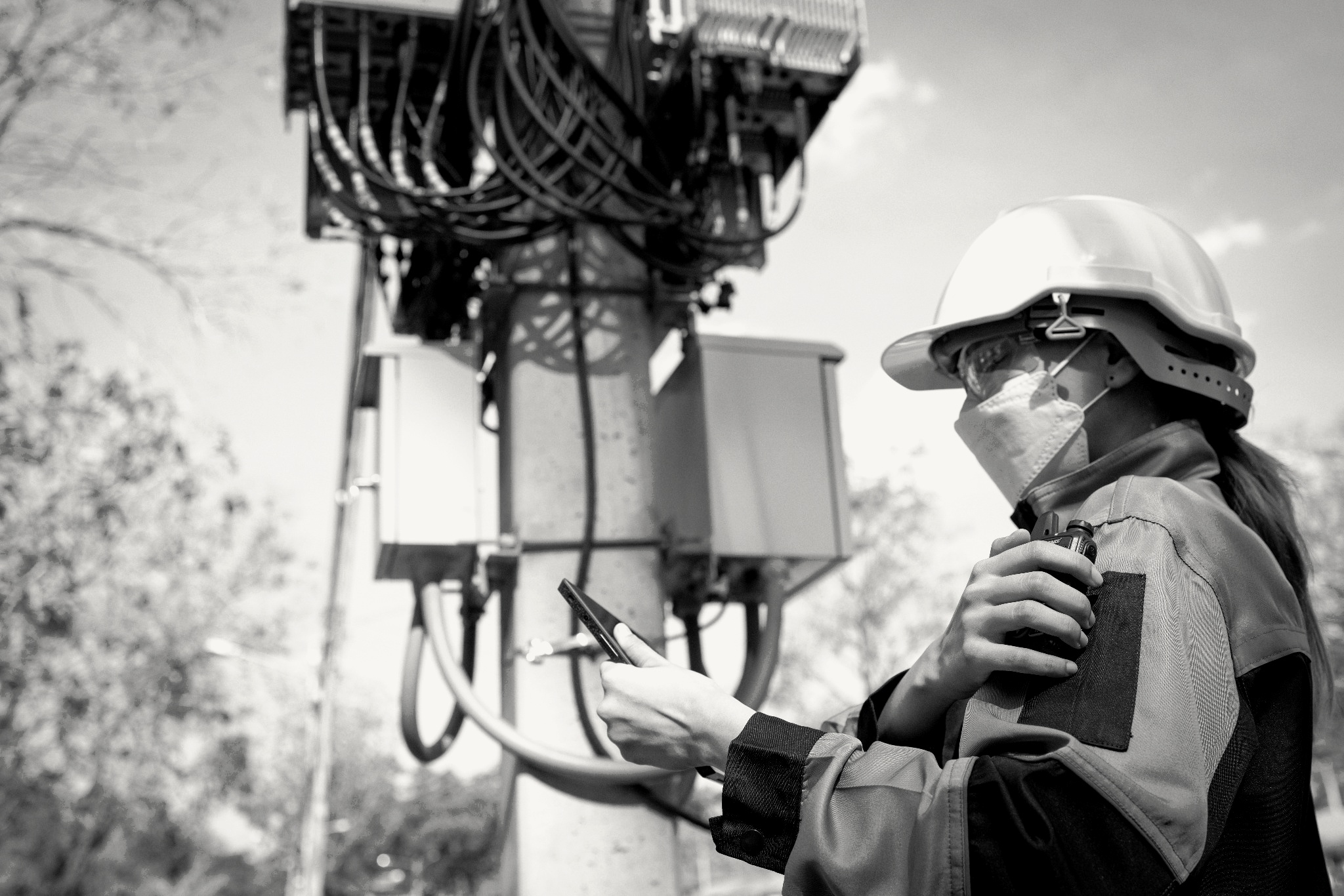 Technician inspecting communications equipment at a field site